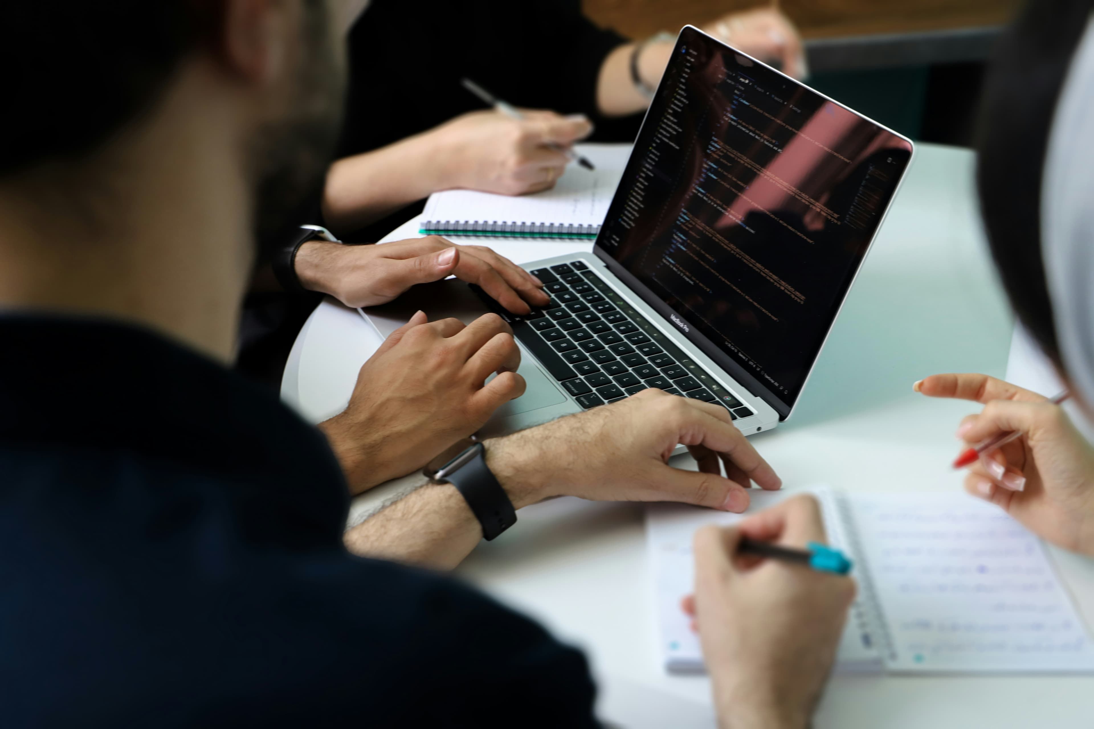 Two people reviewing notes on a table during a working meeting.